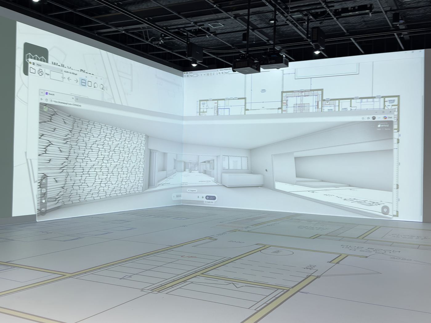 A 3D interior walkthrough of a home projected on the walls of a pADS design room, with the floor plan laid out on the floor